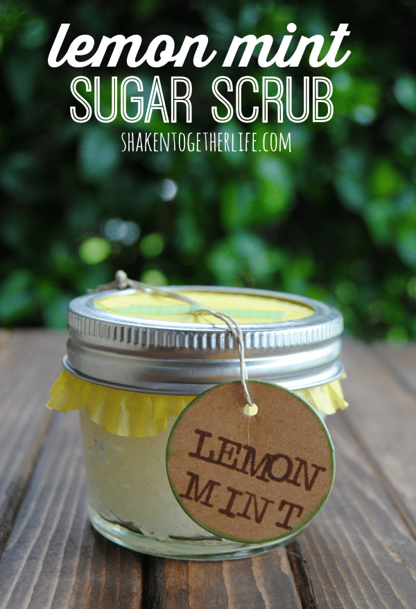 a small mason jar of lemon mint scrub on a wooden table with trees in the background