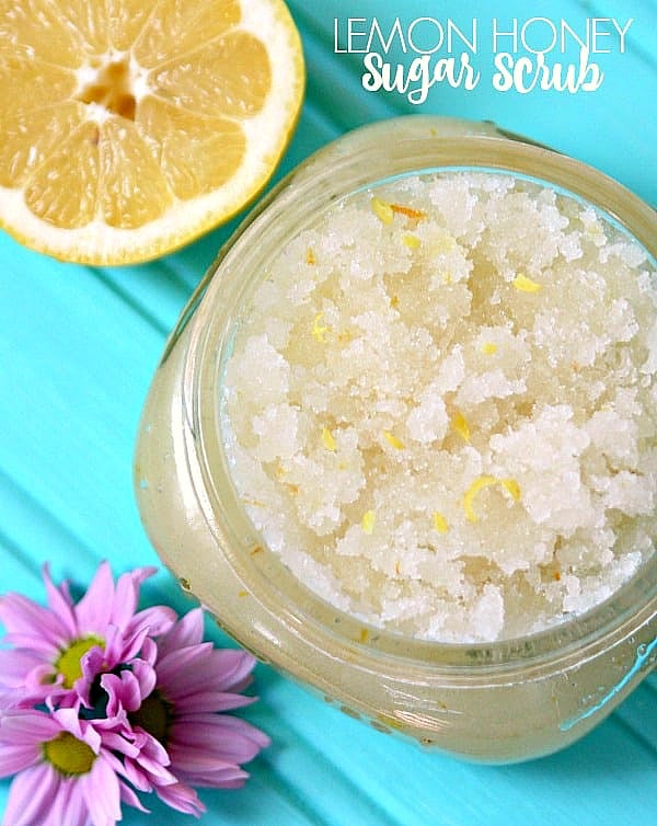 lemon wedge and a jar of lemon honey scrub on a teal table