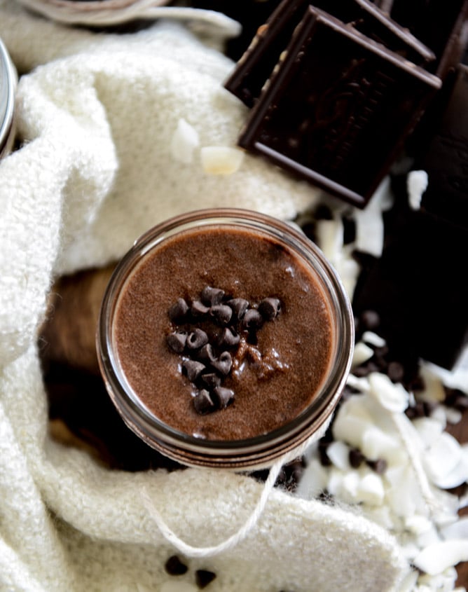 chocolate sugar scrub in a glass jar with chocolate chips on top