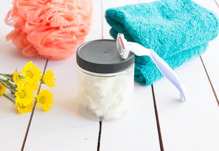 glass jar of homemade shaving cream with a razor and towel