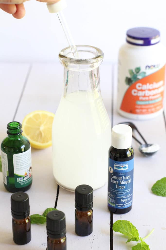Ingredients for homemade mouthwash on a table with a glass bottle