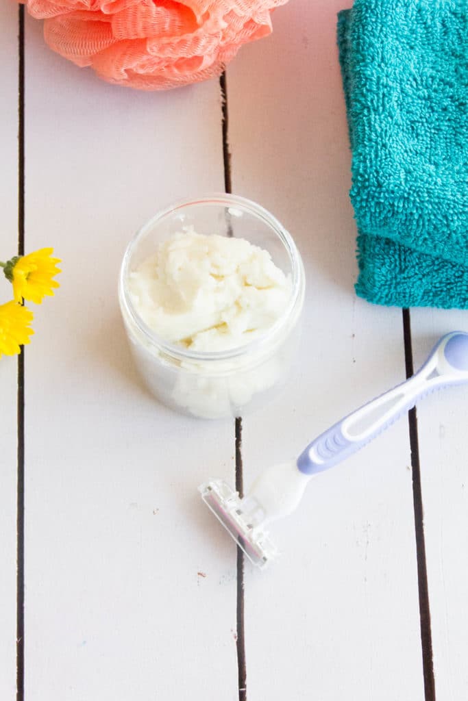 DIY shaving cream lotion on a white table with a razor and towel