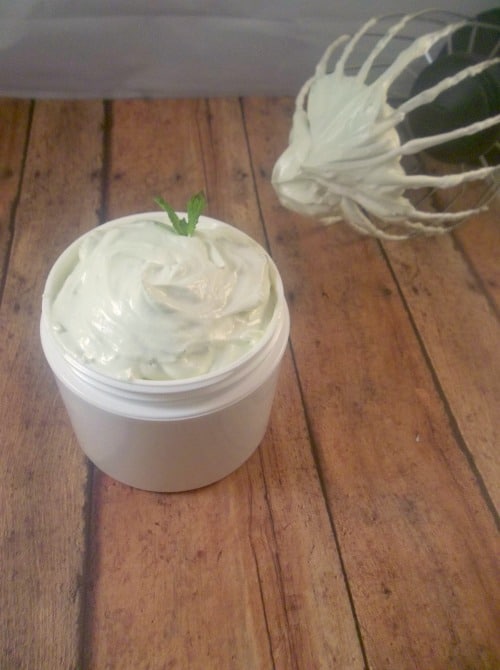 Freshly whipped green tea body butter in a jar on a wooden table